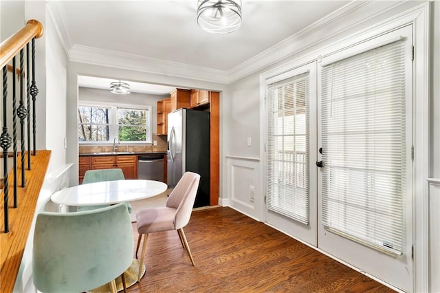 dining room with hardwood / wood-style flooring, sink, and ornamental molding