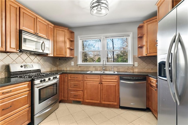 kitchen with decorative backsplash, sink, light tile patterned floors, and appliances with stainless steel finishes