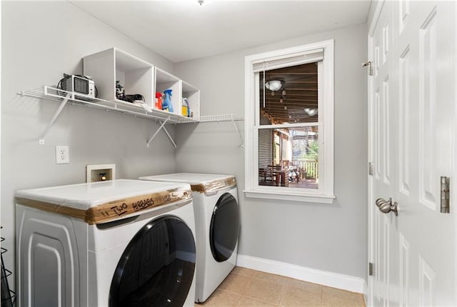 laundry area featuring washer and dryer and light tile patterned flooring