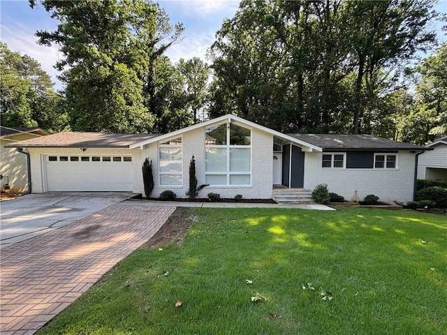 453 James St SW, Lilburn, GA 30047 - view of front of house with concrete driveway, brick siding, a garage, and a front lawn