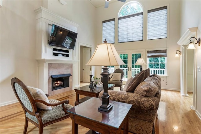 135 Stone Orchard Ct, Milton, GA 30004 - living room with a high ceiling, a tiled fireplace, baseboards, light wood-style floors, and ceiling fan