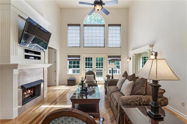 135 Stone Orchard Ct, Milton, GA 30004 - living area featuring ceiling fan, wood finished floors, a tile fireplace, a high ceiling, and ornamental molding