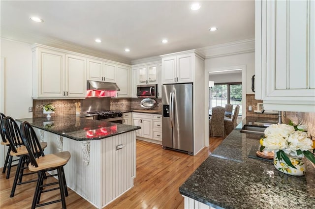 135 Stone Orchard Ct, Milton, GA 30004 - kitchen with appliances with stainless steel finishes, under cabinet range hood, a peninsula, white cabinets, and light wood finished floors