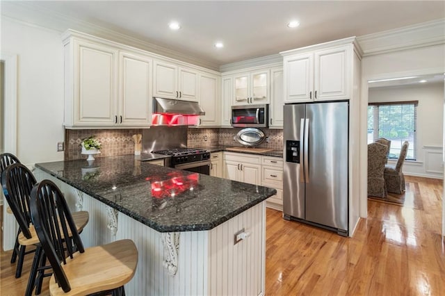 135 Stone Orchard Ct, Milton, GA 30004 - kitchen with stainless steel appliances, under cabinet range hood, a peninsula, light wood-type flooring, and white cabinetry