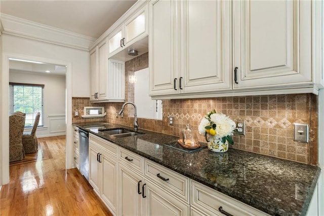 135 Stone Orchard Ct, Milton, GA 30004 - kitchen with a sink, stainless steel dishwasher, light wood finished floors, backsplash, and dark stone countertops