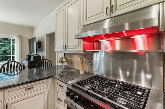 135 Stone Orchard Ct, Milton, GA 30004 - kitchen featuring under cabinet range hood, tasteful backsplash, cream cabinets, ornamental molding, and dark stone countertops