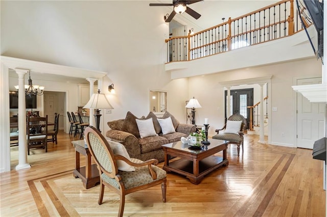 135 Stone Orchard Ct, Milton, GA 30004 - living room featuring ceiling fan, a high ceiling, light wood finished floors, baseboards, and a chandelier