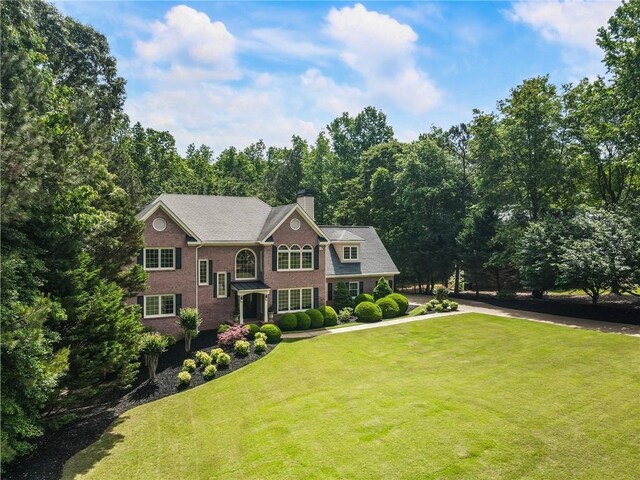 135 Stone Orchard Ct, Milton, GA 30004 - view of front of house featuring a chimney, a front lawn, and brick siding