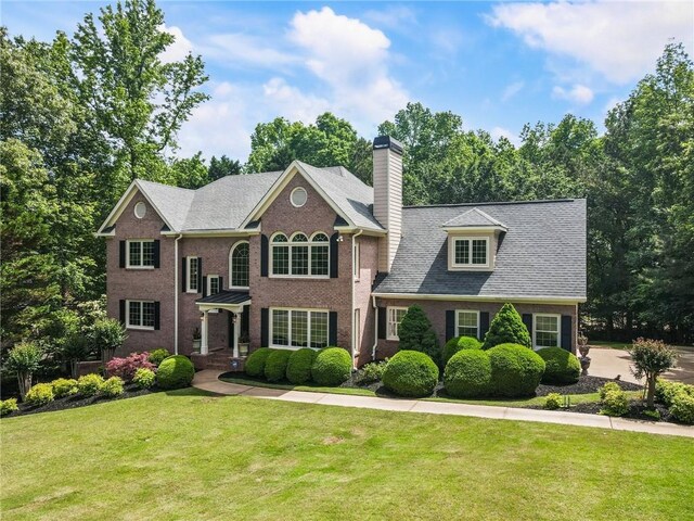 135 Stone Orchard Ct, Milton, GA 30004 - colonial inspired home with a front yard, a chimney, and brick siding