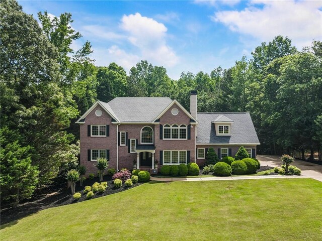 135 Stone Orchard Ct, Milton, GA 30004 - colonial inspired home with a chimney, a front yard, and brick siding