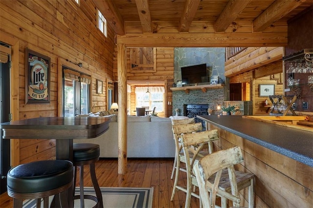 kitchen featuring a fireplace, wood-type flooring, wooden ceiling, and beamed ceiling