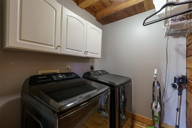 laundry room with wooden ceiling, cabinets, and washing machine and clothes dryer