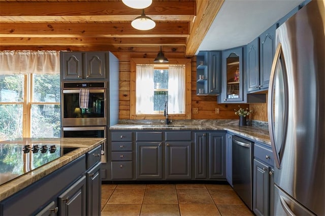 kitchen featuring dark tile patterned floors, stainless steel appliances, decorative light fixtures, and gray cabinetry