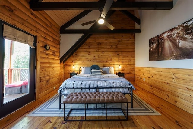 bedroom featuring vaulted ceiling with beams, wood-type flooring, and wood walls
