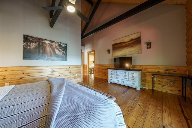 bedroom featuring beam ceiling, hardwood / wood-style flooring, wooden walls, and high vaulted ceiling
