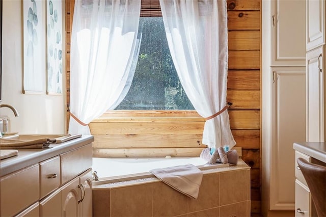 bathroom featuring vanity and tiled tub