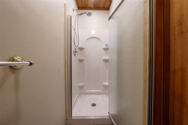 bathroom with a shower and wooden ceiling