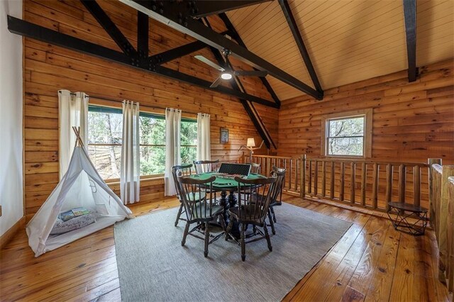 dining space featuring lofted ceiling with beams, a healthy amount of sunlight, and hardwood / wood-style floors