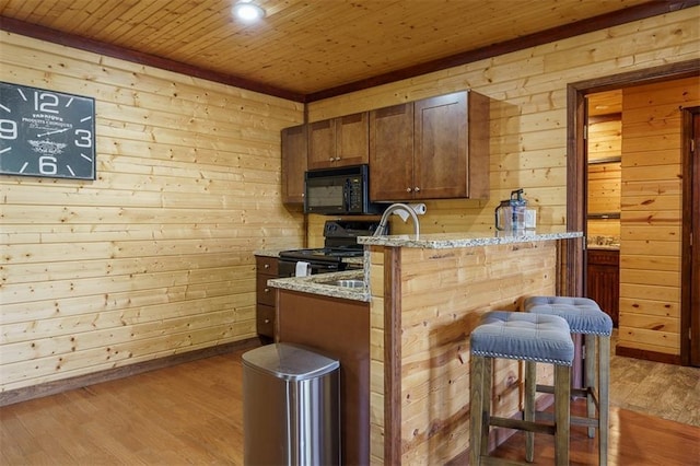 kitchen with wood-type flooring, light stone countertops, wood ceiling, and black appliances