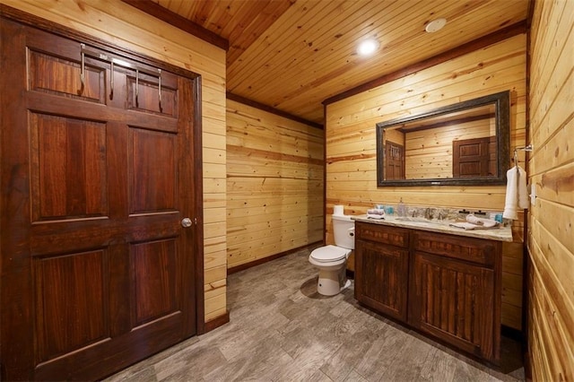 bathroom with wooden ceiling, vanity, toilet, and wood walls