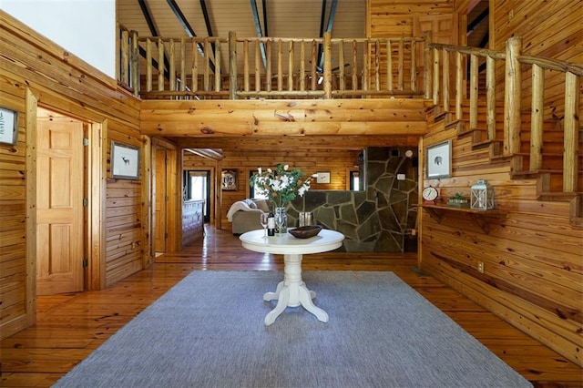 entryway with hardwood / wood-style floors, a high ceiling, and wood walls