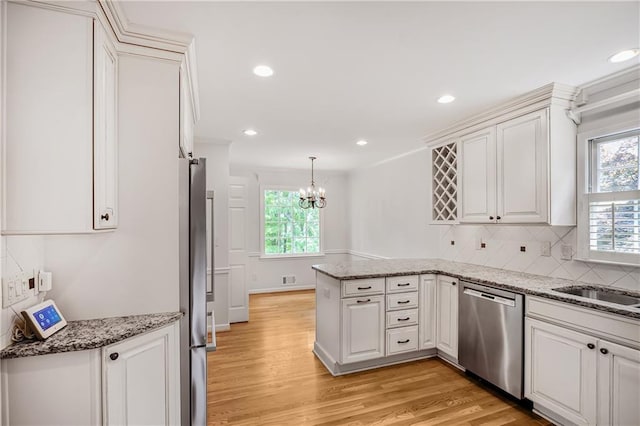 3320 Woodleaf Way, Marietta, GA 30062 - kitchen featuring stainless steel appliances, a peninsula, plenty of natural light, light wood finished floors, and recessed lighting