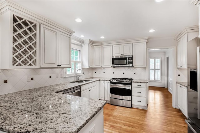 3320 Woodleaf Way, Marietta, GA 30062 - kitchen with appliances with stainless steel finishes, a sink, a peninsula, decorative backsplash, and ornamental molding