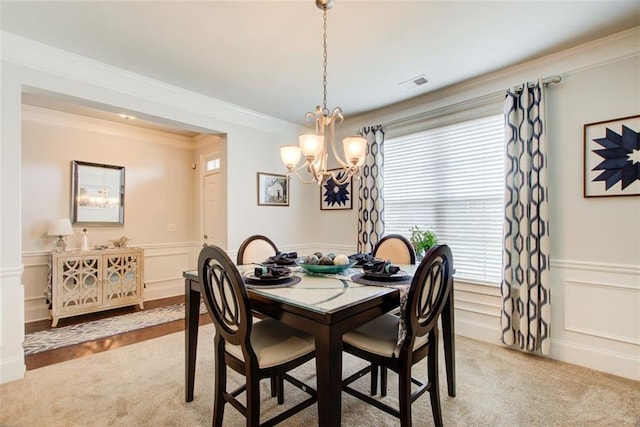 555 Lance View Ln, Lawrenceville, GA 30045 - dining area with a chandelier, healthy amount of natural light, light colored carpet, a decorative wall, and crown molding