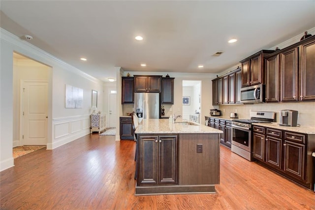 555 Lance View Ln, Lawrenceville, GA 30045 - kitchen with appliances with stainless steel finishes, ornamental molding, a sink, dark brown cabinetry, and light stone counters