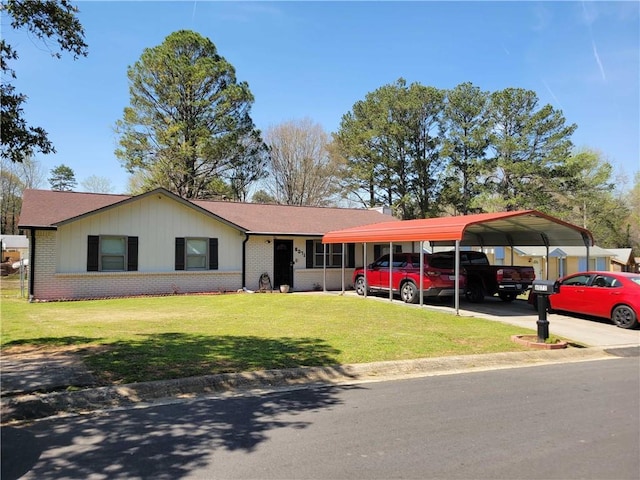 ranch-style house with a front yard, driveway, a detached carport, and brick siding