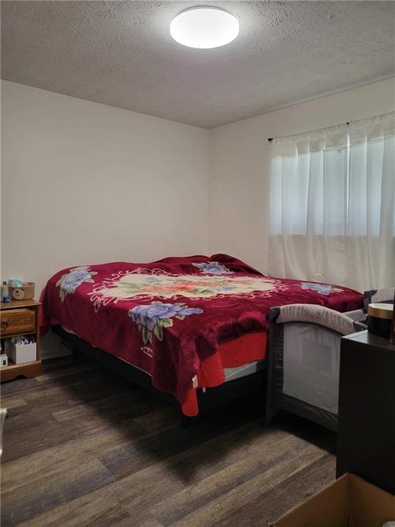 bedroom with a textured ceiling and wood finished floors