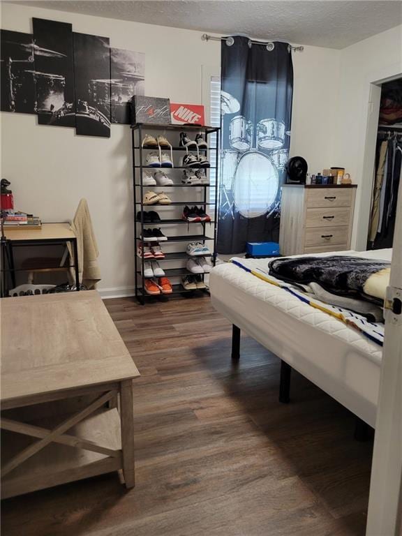 bedroom with dark wood-style flooring, baseboards, and a textured ceiling