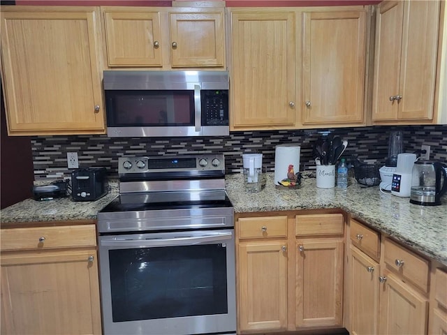 kitchen featuring backsplash, light stone countertops, appliances with stainless steel finishes, and light brown cabinets