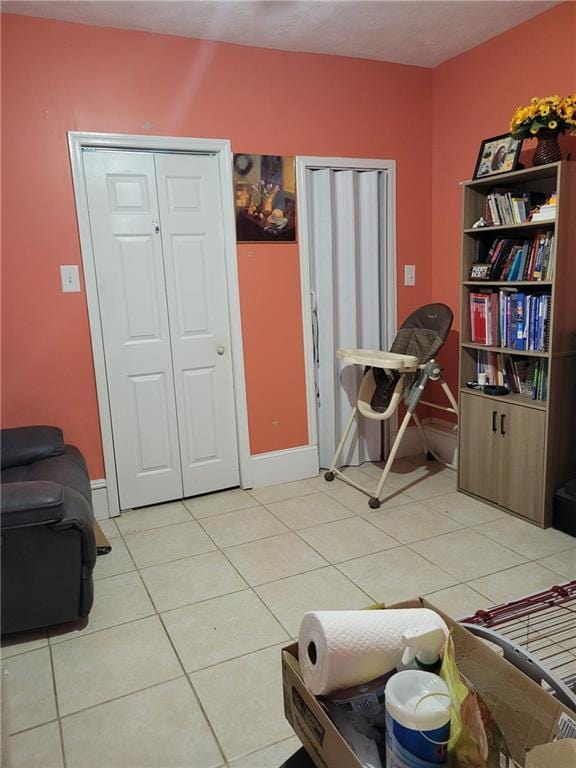 bedroom with light tile patterned floors and baseboards