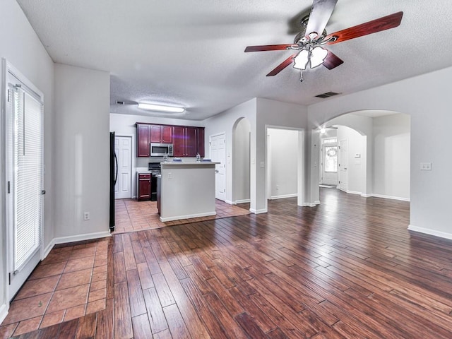 20 Preserve Dr, Newnan, GA 30263 - unfurnished living room featuring arched walkways, ceiling fan, dark wood-style flooring, and a textured ceiling