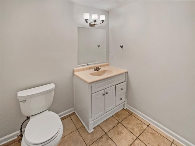 bathroom with toilet, tile patterned floors, and vanity