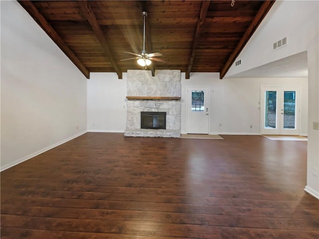 unfurnished living room with a stone fireplace, wood ceiling, vaulted ceiling with beams, dark wood-type flooring, and ceiling fan