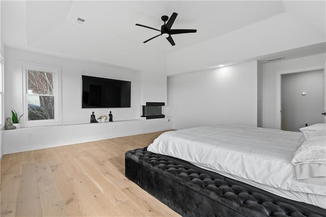 bedroom featuring a tray ceiling, hardwood / wood-style flooring, and ceiling fan