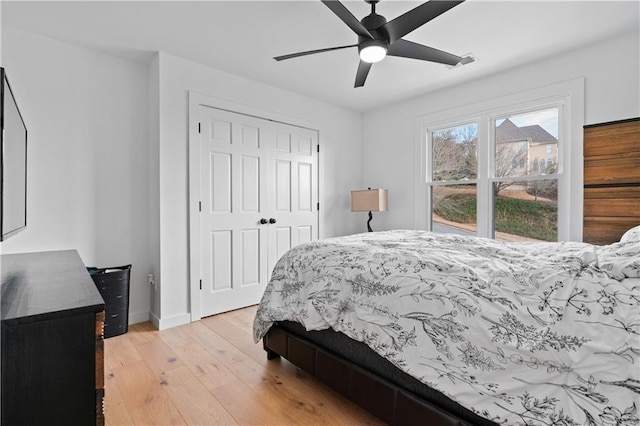 bedroom with light wood-type flooring, a closet, and ceiling fan