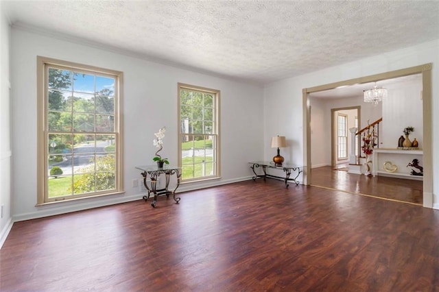 interior space with a textured ceiling, wood finished floors, and a wealth of natural light