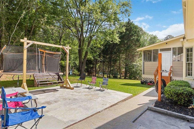 view of patio featuring a sunroom and a trampoline