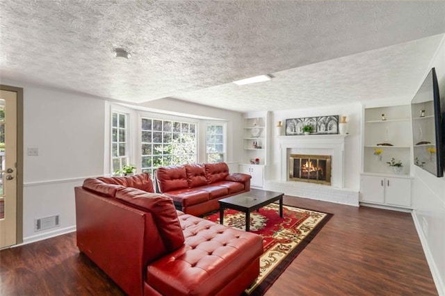 living area featuring visible vents, a textured ceiling, and wood finished floors