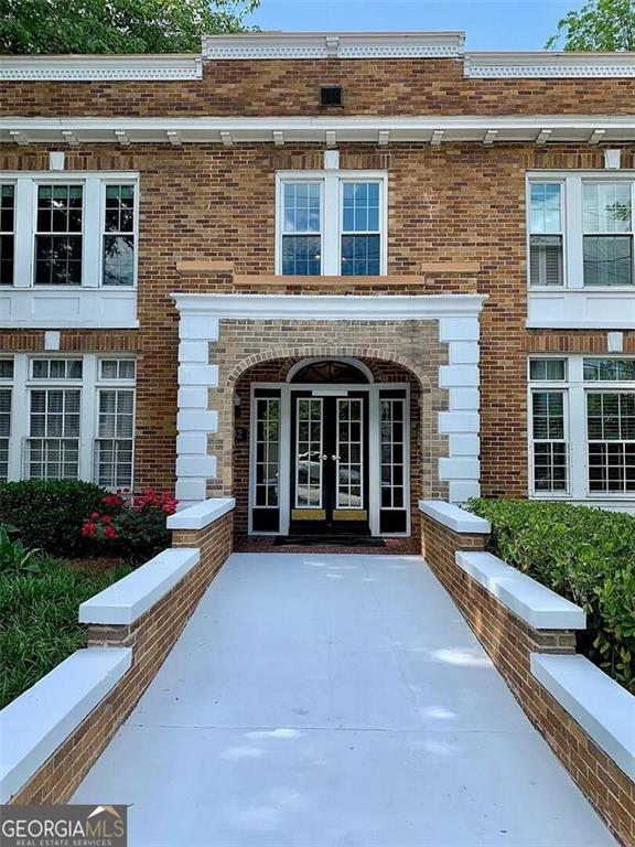 view of exterior entry with brick siding and french doors