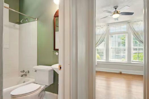 242 12th St NE Unit 1A, Atlanta, GA 30309 - bathroom with toilet, baseboards, shower / washtub combination, wood finished floors, and ceiling fan