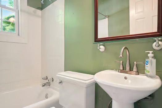 242 12th St NE Unit 1A, Atlanta, GA 30309 - bathroom with toilet, tub / shower combination, and a sink