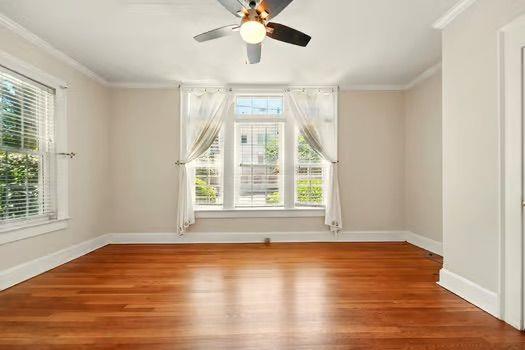 242 12th St NE Unit 1A, Atlanta, GA 30309 - unfurnished room featuring crown molding, baseboards, wood finished floors, and a ceiling fan