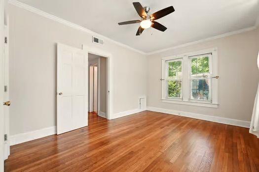 242 12th St NE Unit 1A, Atlanta, GA 30309 - spare room featuring ornamental molding, wood finished floors, baseboards, and a ceiling fan