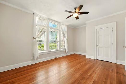 242 12th St NE Unit 1A, Atlanta, GA 30309 - spare room featuring ornamental molding, wood finished floors, baseboards, and ceiling fan