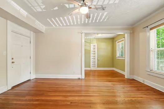 242 12th St NE Unit 1A, Atlanta, GA 30309 - unfurnished room featuring wood finished floors, ceiling fan, ornamental molding, and baseboards