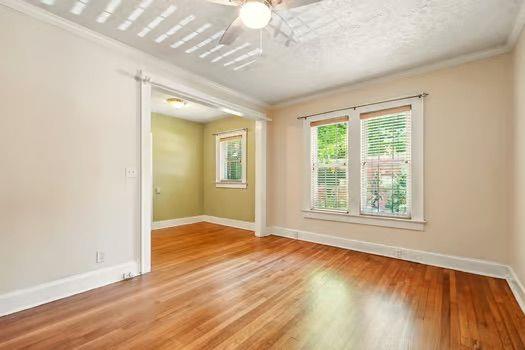 242 12th St NE Unit 1A, Atlanta, GA 30309 - unfurnished room with baseboards, ornamental molding, wood finished floors, and ceiling fan